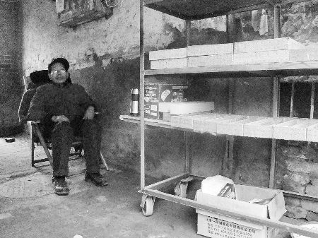  在不到3平方米的摊位前，邱宏修躺在笔架后的藤椅上。